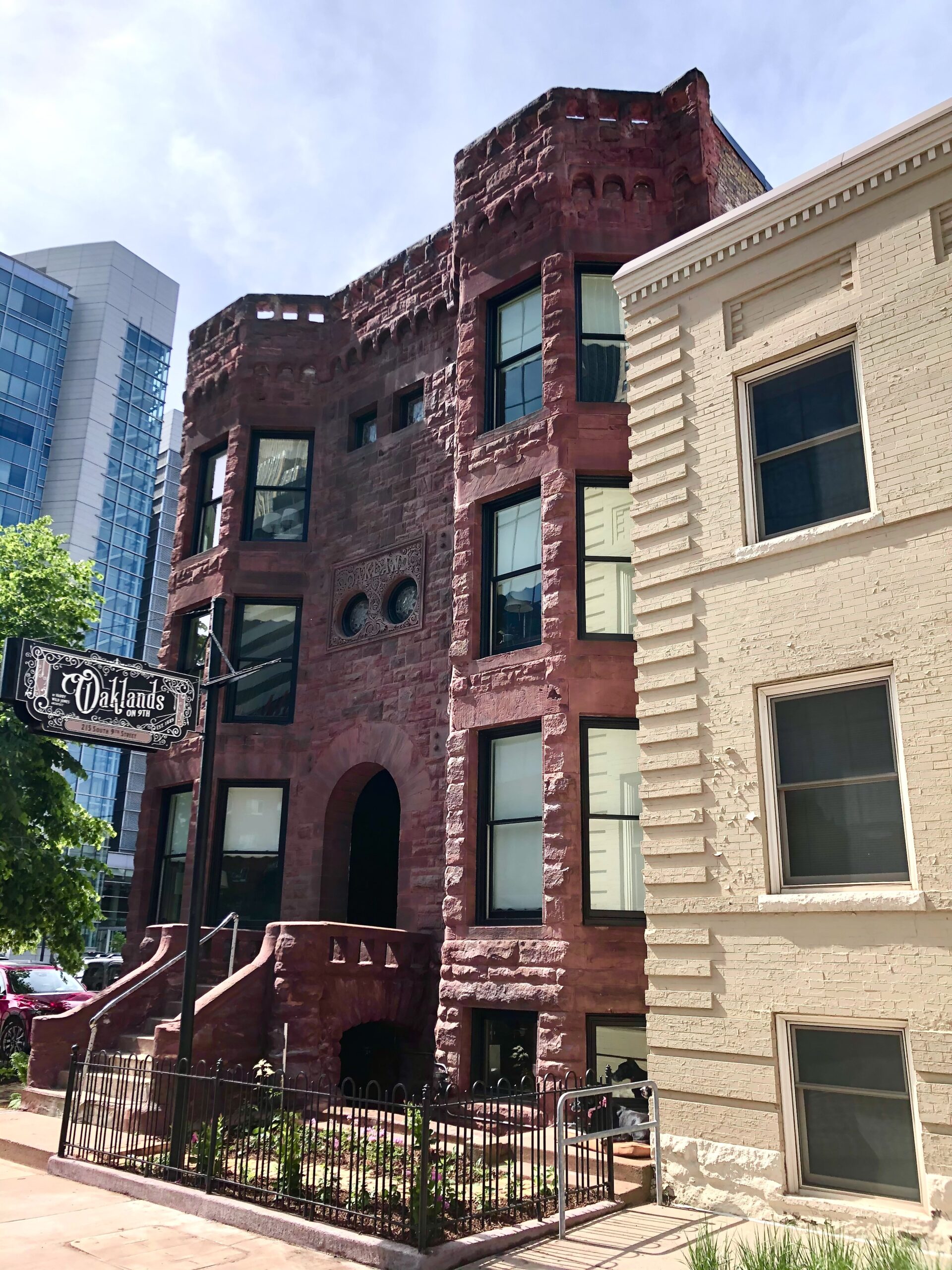 The hanging Oaklands on 9th sign on the 1889 brownstone front, marking the furnished extended-stay studios in downtown Minneapolis.