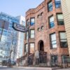 The 1889 Oaklands on 9th brownstone on South 9th Street in downtown Minneapolis, with a modern glass office tower rising behind it.
