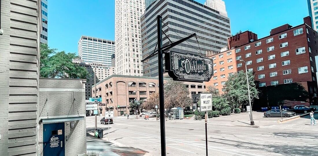 The Oaklands on 9th garden patio with downtown Minneapolis high-rises rising behind it on a clear summer day