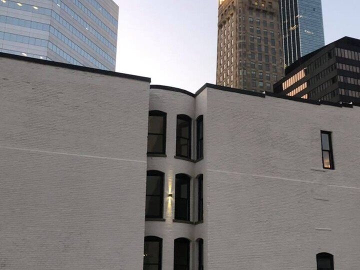The Oaklands on 9th brownstone at dusk in downtown Minneapolis with the lit Foshay Tower glowing behind it