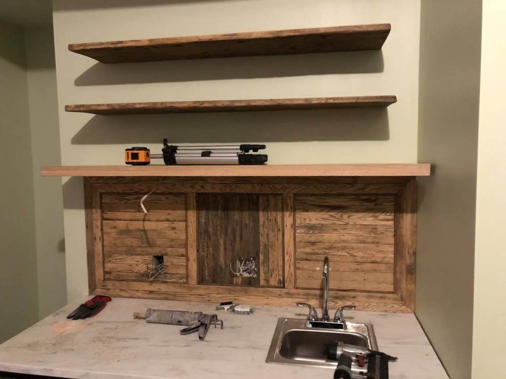 Kitchen backsplash and floating shelves built from the Oaklands on 9th building's own reclaimed oak flooring.