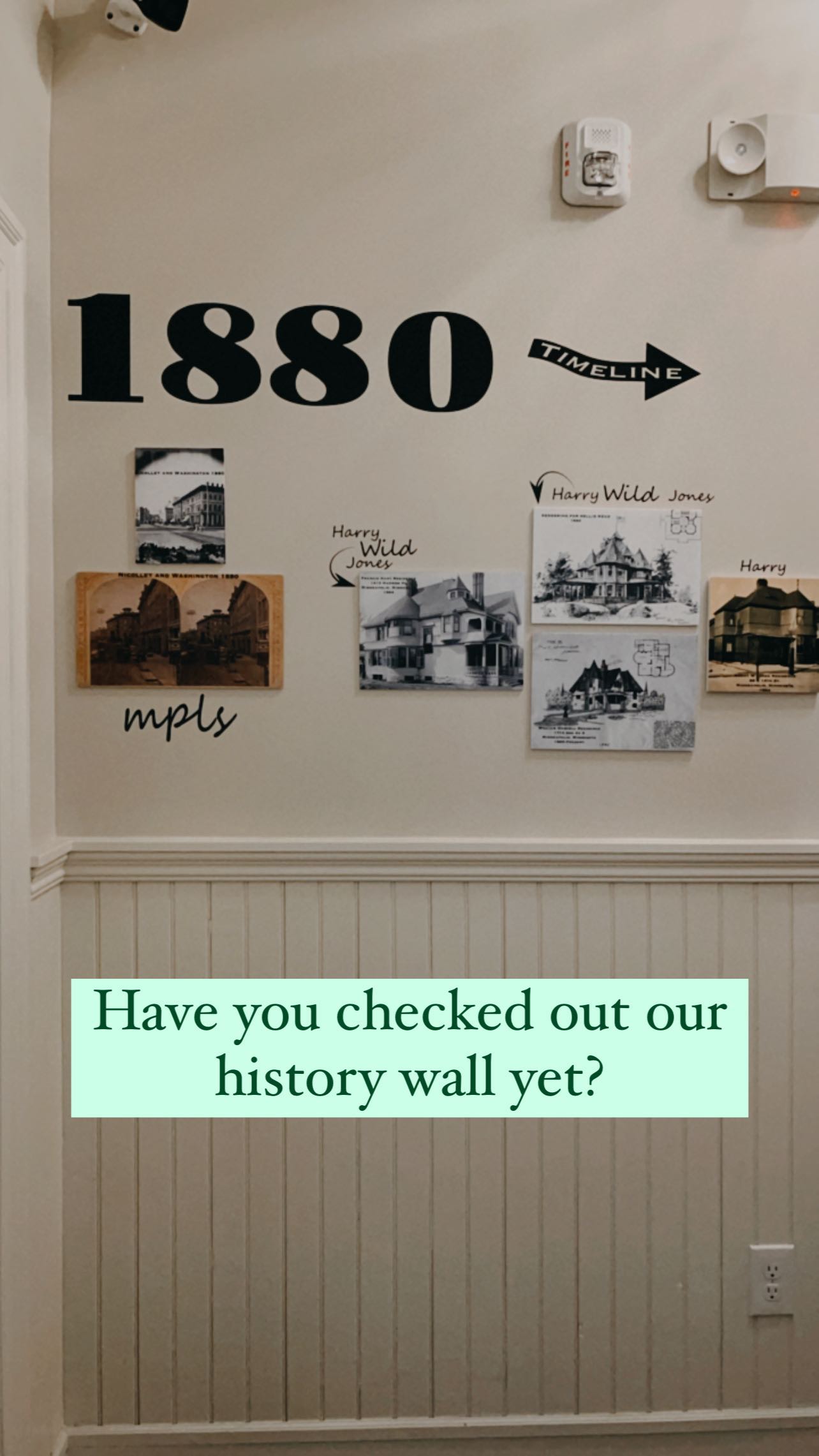 The history wall in an Oaklands on 9th hallway: an 1880 Minneapolis timeline with archival photos of Harry Wild Jones houses.