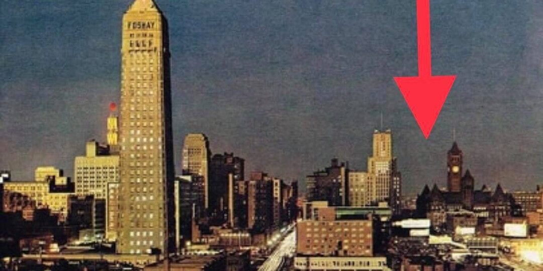 1959 photo of downtown Minneapolis at dusk with the Foshay Tower rising above 9th Street; a red arrow marks the Oaklands building